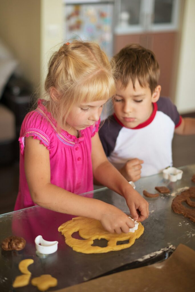 Children cutting cookies from dough